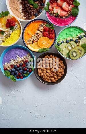 Various healthy fresh smoothies or yogurts in bowls. With strawberries, kiwi, chia, blackberries Stock Photo
