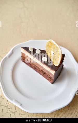 Chocolate sponge cake, with mousse, decorated with Orange slice and meringue. Breakfast in the cafe, morning coffee. on wooden table. Stock Photo