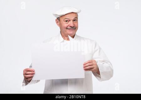 Senior cook man holding sign speech bubble smiling delighted. Isolated on white background. Stock Photo