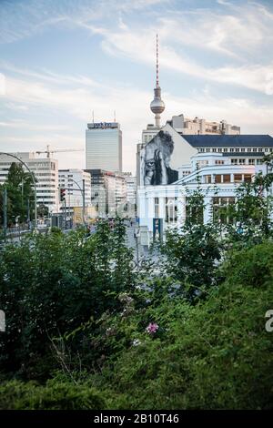 Prenzlauer Allee, Prenzlauer Berg, view towards the center of the TV tower and Park Inn, right on the street art by JR, Berlin, Germany Stock Photo