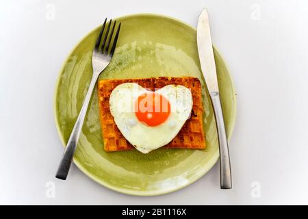 Heart shaped fried egg on toasted waffle Stock Photo