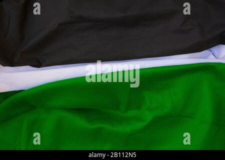 Cloth waves close up the background, Stacked Creased fabric 3 color black green white, elegant wallpaper design, wavy folds of grunge silk texture sat Stock Photo
