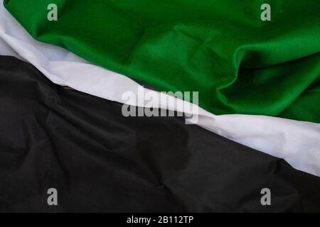 Cloth waves close up the background, Stacked Creased fabric 3 color black green white, elegant wallpaper design, wavy folds of grunge silk texture sat Stock Photo