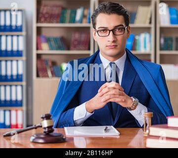 The handsome judge with gavel sitting in courtroom Stock Photo
