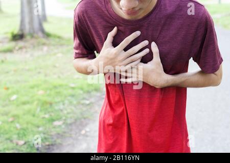 Sport man suffering from chest pain heart attack after running. Stock Photo
