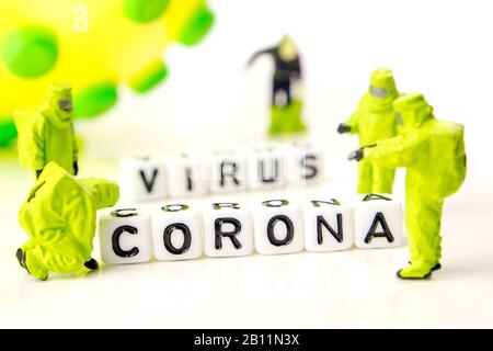 closeup of big corona virus with a team of special medical forces miniature figurines interfering during gas and other chemical accidents, the team pr Stock Photo