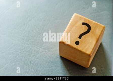 Wooden toy block with printed question mark Stock Photo