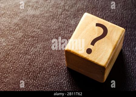 Wooden toy block with black question mark Stock Photo