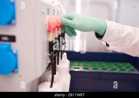 Close-up of chemist in protective gloves working with equipment in the lab Stock Photo