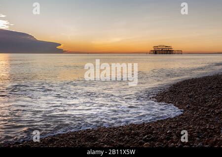 wave breaking on Brighton seafront at dusk Stock Photo