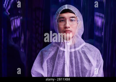 Portrait of Asian young chemist in protective workwear working at lab with chemicals Stock Photo
