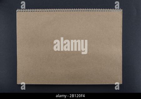 Blank brown notebook with space for text on black background. Empty notebook with brown texture. Copy space for add text or art work designs. Stock Photo