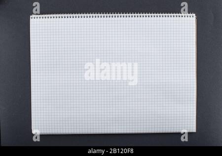 Blank notebook with space for text on black background. Empty notebook with white texture and brown grid lines. Copy space for add text or art work Stock Photo