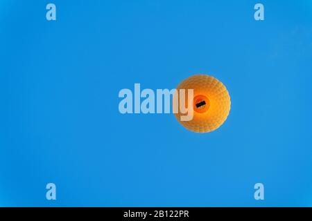 Yellow hot air balloon on blue sky. Stock Photo