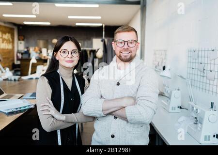 Two young contemporary fashion designers or tailors crossing their arms by chest Stock Photo