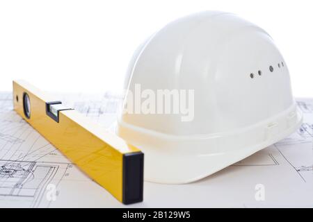 White hard hat and yellow level lying on construction plan - white background Stock Photo