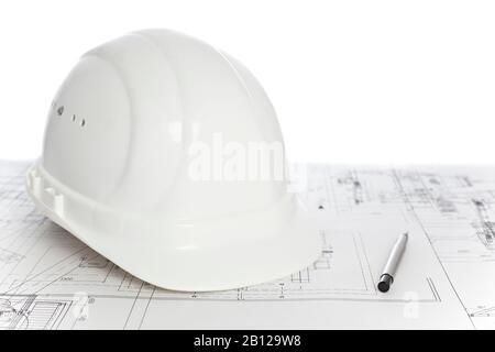 White hard hat and ballpen lying on a construction plan - white background Stock Photo