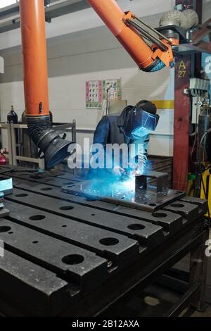 Professional welder in workwear and protective mask doing welding work Stock Photo