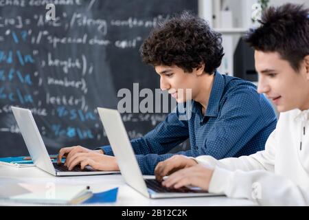 Two university students scrolling through online information for their project Stock Photo