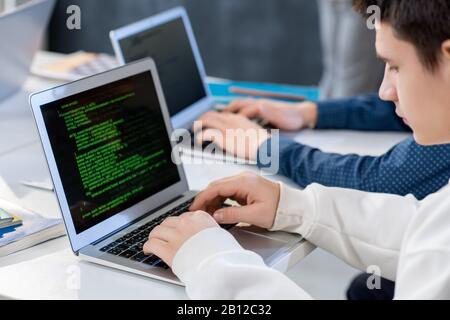 One of students or programmers in front of laptop entering technical data Stock Photo