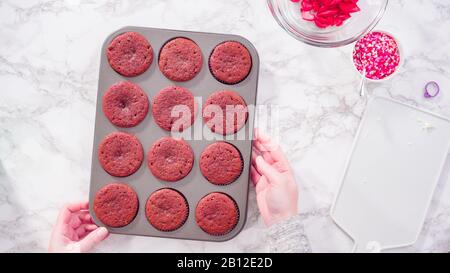 Flat lay. Step by step. Cooling red velvet cupcakes on a kitchen drying rack. Stock Photo