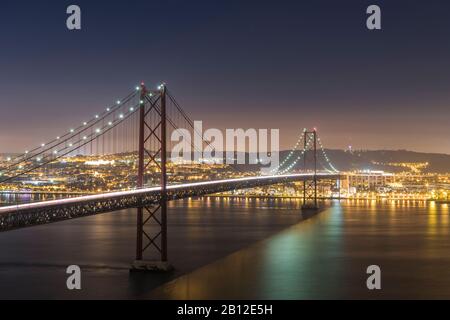 Night shot of Ponte 25 de Abril (bridge) and Lisbon, Portugal Stock Photo