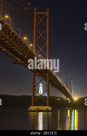 Night shot of Ponte 25 de Abril (bridge) and Cristo Rei (Christ statue in Almada), Lisbon, Portugal Stock Photo