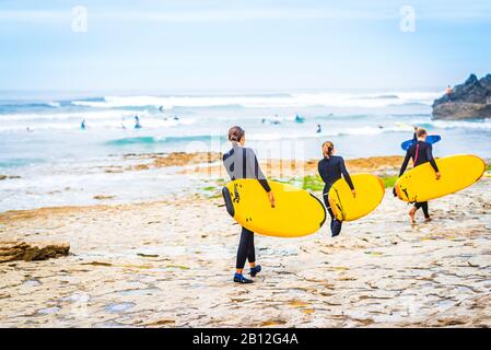 View on group of surfer at the beach of Ribeira d'Ilhas next to Ericeira, Portugal Stock Photo