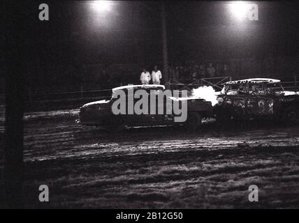 1970s, historical, a banger racing car with smoke pouring out from a ...