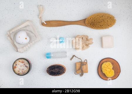 bath accessories, soaps, body brush, scrub with rose leaves, bottles for cosmetic, sponge on white background, top view, close up. Spa concept Stock Photo