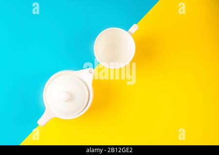 Tea pot and tea mug on a yellow and blue background Stock Photo