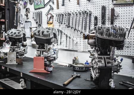 Three vintage Harley Davidson engines on display in a garage. Stock Photo