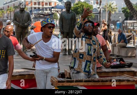 Cape Town, South Africa. December 2019. Street musician in colourful clothing plays xylophone on the waterfront area of central Cape Town. Stock Photo