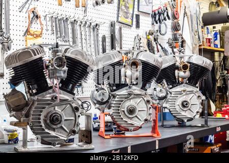 Three vintage Harley Davidson engines on display in a garage. Stock Photo