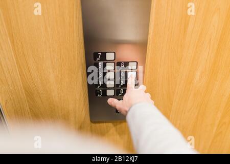 Forefinger pressing fourth floor button in the elevator. Space for copy. Stock Photo