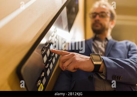 Man pressing modern elevator button with his forefinger. Stock Photo
