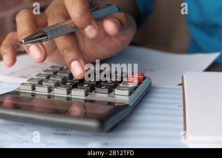 Close up of man hand use calculator on desk  Stock Photo
