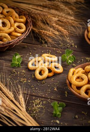 Salty cracker pretzel rings on dark wooden background Stock Photo