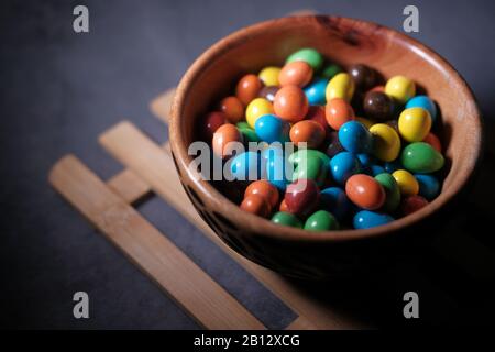top view of colorful chocolate in a bowl on table  Stock Photo