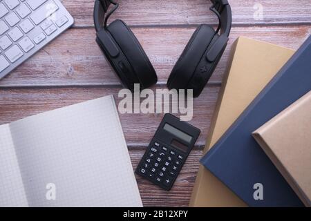 top view of open book, headphone and keyboard on table  Stock Photo