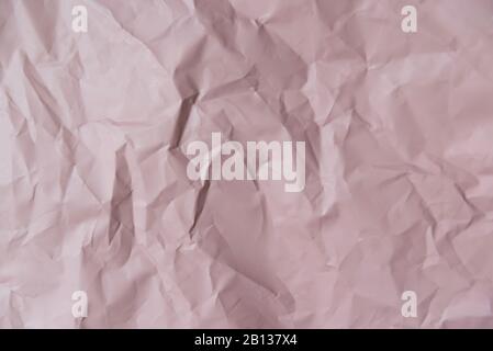 Crumpled craft wrapping paper with hard shadows. Close up, top view. Stock Photo