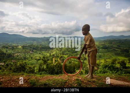 Kid playing with a hoop in the mountain of west Uganda,Africa Stock Photo