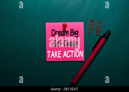 Dream Big Set Goals Take Action write on a sticky note isolated on Office Desk Stock Photo