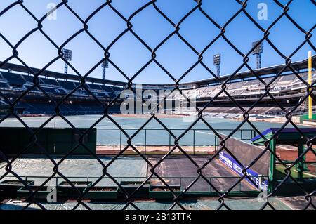 PNC Park, where the Pittsburgh Pirates play baseball as seen through a chain link fence from the outfield as it's getting prepared for the season Stock Photo