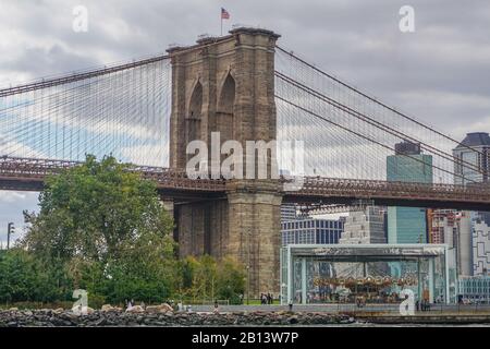 Brooklyn, New York: The Brooklyn Bridge, 1883, and Jane’s Carousel, 1922, in Brooklyn Bridge Park. Stock Photo