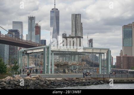 Brooklyn, New York: Jane’s Carousel, 1922, in Brooklyn Bridge Park, with the Brooklyn Bridge and Freedom Tower in the background. Stock Photo