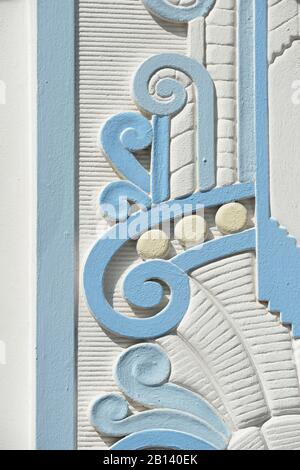 Art Deco stone relief, detail. Stylized ocean and tropical plant motifs on exterior wall of building. Swirling waves, sand and palm tree patterns. Stock Photo