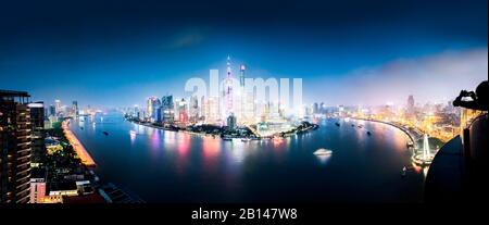 Shanghai skyline with Shanghai Tower, Shanghai World Financial Center, Pudong Oriental Pearl Tower and huangpu river during the blue hour, panorama with silhouette of a tourist, lujiazui, pudong, shanghai, china, asia.