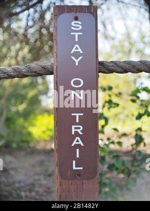 "Stay on trail" sign in a park Stock Photo
