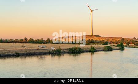 Evening at the River Ruhr with a wind turbine in the background, seen in Duisburg, North Rhine-Westfalia, Germany Stock Photo